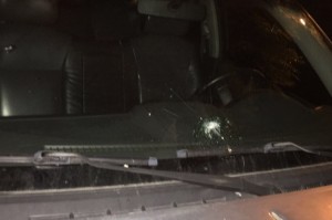 Vidrio delantero del vehículo con un agujero de bala.