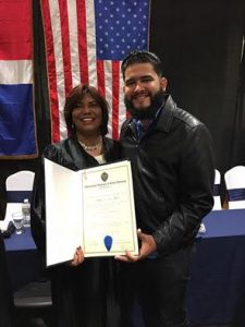 Néstor Matos hace entrega del certificado de graduación a Nathalia Romano. 