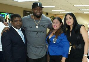 El beisbolista David Ortiz pusa junto al vicepresidente del CONDEX, Ramiro Espino y parte del equipo de recepción en el AILA.
